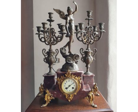 A French mantle clock, with a spelter angel figural finial, 64 cm high and a pair of matching candleabra (3) 