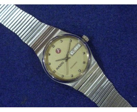 Rado: A gentleman's stainless steel Voyager day date automatic Wristwatch, the circular champagne dial with baton markers and
