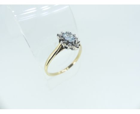 A small Dress Ring, the centre with a pear shaped pale aquamarine, surrounded by ten small diamonds, mounted in yellow gold, 