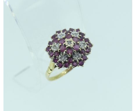 A ruby and diamond cluster Ring, of hexagonal form, mounted in silver and 9ct yellow gold, Size V.