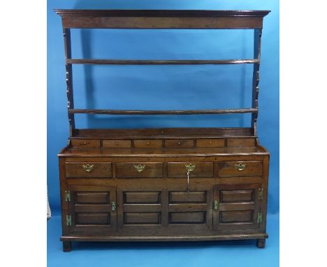 An 18thC oak Welsh Dresser, the plate rack with three open shelves above six spice drawers, atop a base of joined constructio