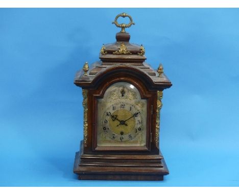 An early 20th century German walnut chiming bracket clock, of arched form with gilt metal mounts, silvered dial with gilt hig