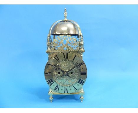 A brass mantel clock in the form of a 17th century Lantern Clock, with an 8-day twin-fusee movement striking on a bell, the p