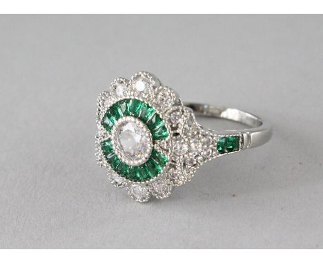 A SILVER FAUX EMERALD ART DECO DESIGN RING.