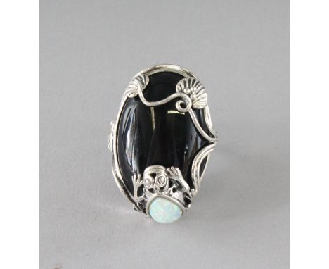 A SILVER, ONYX AND OPAL FROG RING.