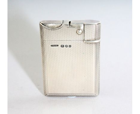 AN ASPREY ENGINE TURNED SILVER PETROL LIGHTER. London 1956.