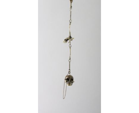 A BRASS SKULL SNUFF BOX on a chain.