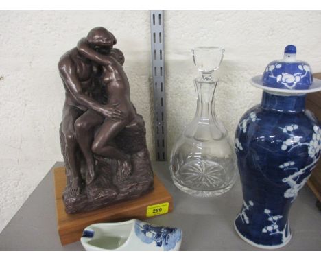 A bronzed composition group of an embracing couple, a Charles and Diana decanter, an Imari vase and cover and a Delft clog 