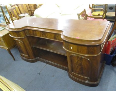 A Victorian mahogany cushion moulded sideboard having two central shelves flanked by cupboards and drawers on a plinth base, 