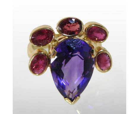 A large designer 18 carat gold, tanzanite and ruby cluster ring, the central tear shaped stone, surrounded by five collet set