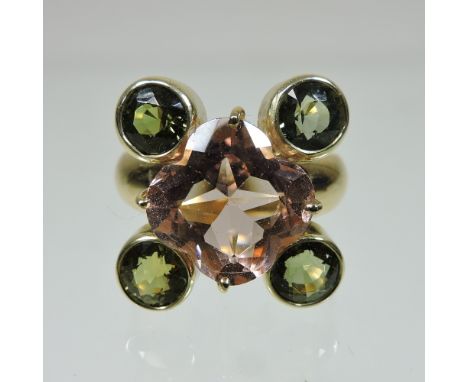 An 18 carat gold rose quartz and peridot cluster ring, set with a central cushion cut stone, surrounded by four collet set st