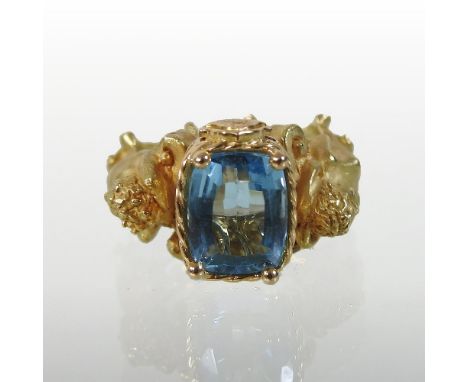 An Italian 18 carat two colour gold blue topaz dress ring, the central stone with a rope twist surround, flanked by two carya