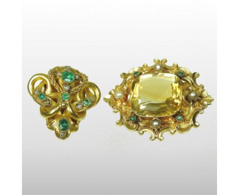 A Victorian style unmarked citrine, emerald and pearl brooch, the large central stone set within an ornate scrolled surround,