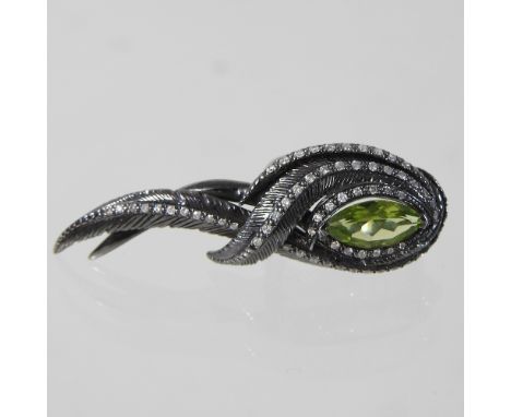 A Georgina Chapman for Garrards sterling silver, peridot and diamond two finger ring, of feather design, with a central marqu