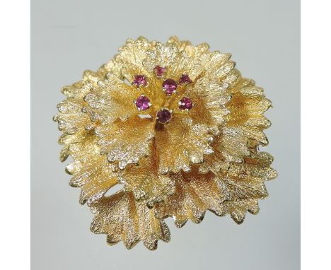 A contemporary 18 carat gold and ruby set ladies brooch, of flower head design, stamped DJE, 4cm diameter, 16g gross