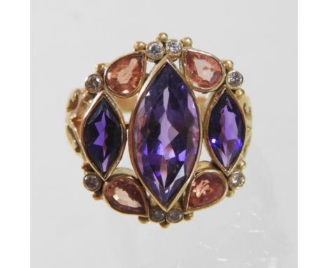 An unmarked diamond, tanzanite and gem set ring, set with three central elliptical stones, within a diamond surround, 2cm wid