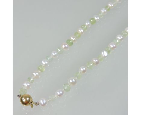 A natural pearl and jade coloured bead necklace, strung with alternating pearls and facet carved beads, with an 18 carat gold