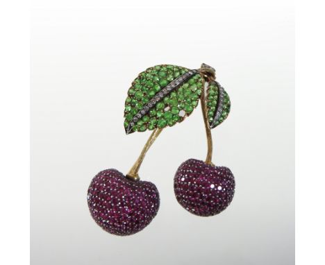 An 18 carat gold emerald, ruby and diamond set brooch, in the form of two cherries on a leaf, (two stones missing), 7cm high,