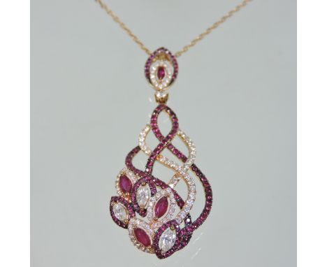 An Italian 18 carat rose gold, ruby and diamond pendant necklace, of entwined asymmetrical design, 6cm long, on a fine 18 car
