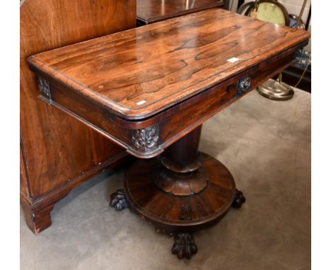 A Regency rosewood card table with rotating folding top, turned column and platform base with lion paw feet, 90 x 45 x 74 cm 