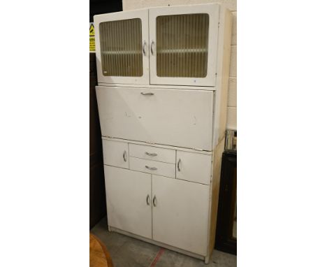 A 1950s vintage kitchen cupboard with etched glass upper doors and melamine drop-front enclosing storage drawers, an arrangem