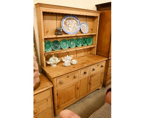 A vintage pine dresser with plate rack over a panelled base with cupboards and three drawers, 145 cm w x 55 cm d x 195 cm h o