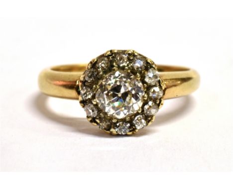 AN ART DECO DAISY DIAMOND RING The ring set with a European cut central diamond, measuring approx 4.5mm in diameter and surro