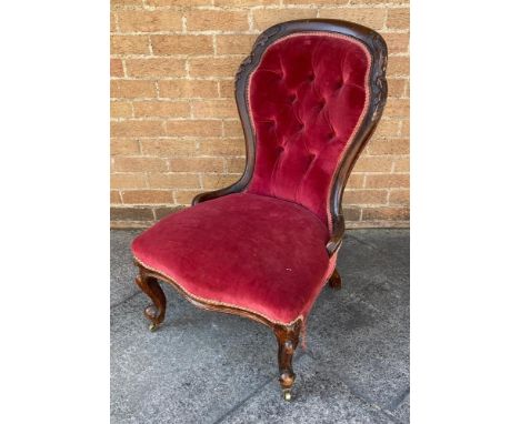 A VICTORIAN CARVED MAHOGANY FRAMED NURSING CHAIR  with button upholstered back, serpentine front seat, on cabriole supports w