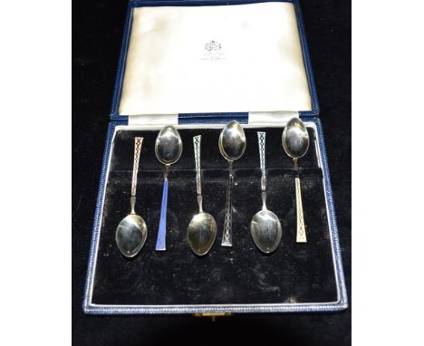 A CASED SET OF SIX SILVER AND ENAMEL TEASPOONS the six teaspoons with coloured enamel to the front of the spoons in individua