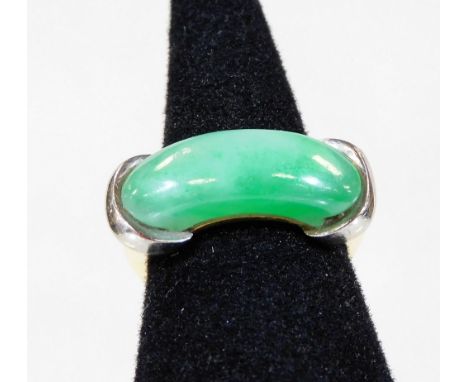 An 18ct white and yellow gold jade dress ring, with curved pale green jade central panel, held by two white gold bands to eac