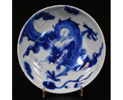 A Chinese porcelain blue and white saucer dish, of circular form decorated with a four clawed dragon in a cloud setting, doub