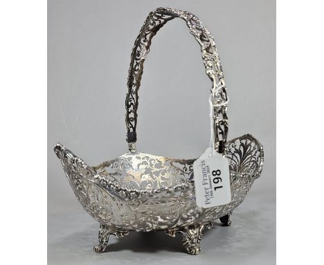 George V silver ornate and pierced basket with swing loop handle on four repoussé scroll feet. By Josiah Williams &amp; Co., 