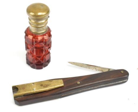 A Victorian rosewood handled quill cutter in carved and leather sheaf and a small ruby flash tinted brass mounted scent bottl