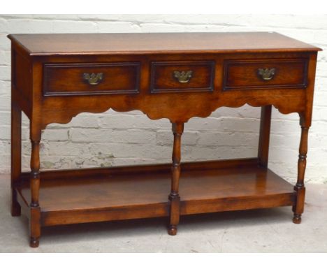 A reproduction oak dresser base with three drawers above under-tier on turned supports, height 89cm, length 139cm, depth 49cm