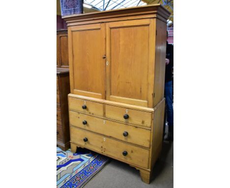 A 19th century pine linen press, the twin panelled doors enclosing two fixed shelves above two short and two long drawers wit