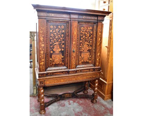 An early 19th century Dutch walnut and marquetry cabinet on stand, the upper section with twin doors featuring further marque