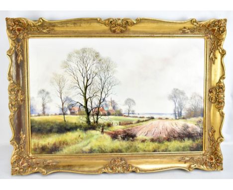 PETER J GREENHILL (BRITISH, 20TH CENTURY); oil on canvas, rural landscape with single figure to foreground and village to bac