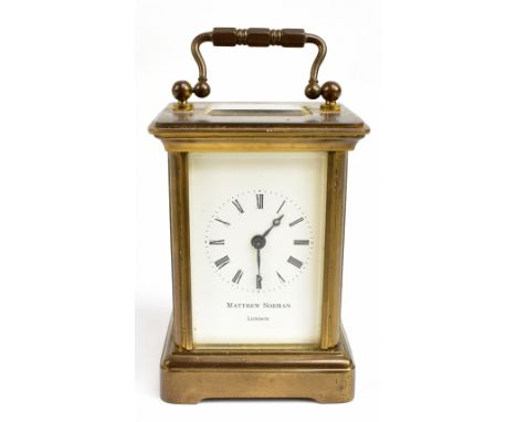 MATTHEW NORMAN; a reproduction brass cased miniature carriage clock, the enamelled dial set with Roman numerals, height inclu