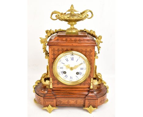 A late 19th century French inlaid kingwood veneered and gilt metal mounted eight day mantel clock with urn surmount above whi