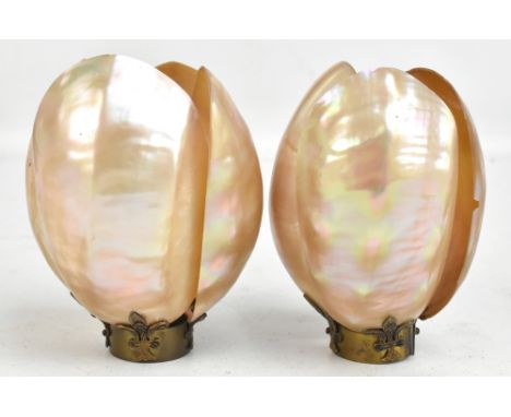 A pair of late 19th century mother of pearl shades on brass stands, each fashioned from four open shells, height 11.5cm (2).A