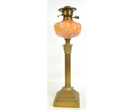 A late 19th/early 20th century brass Corinthian column oil lamp, the glass reservoir with moulded floral decoration, height 6