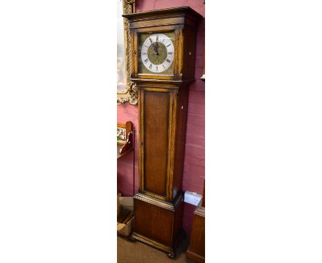 A small early 20th century oak longcase clock with silvered chapter ring inscribed 'E. Buckingham, Levenshulme', height 183cm