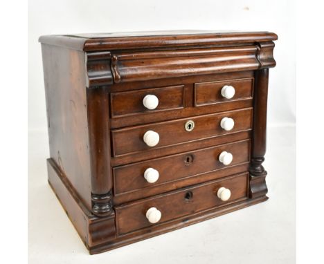A Victorian mahogany miniature chest with secret drawer above two short and three long drawers, with ceramic handles, height 