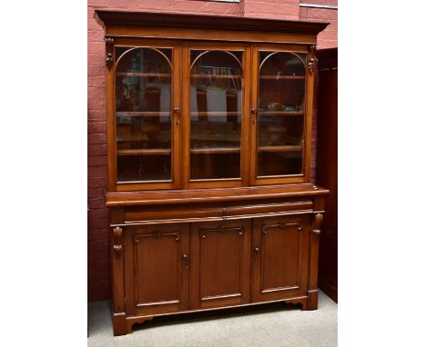 A Victorian mahogany bookcase with moulded cornice above three glazed upper doors and a base of two drawers above twin cupboa