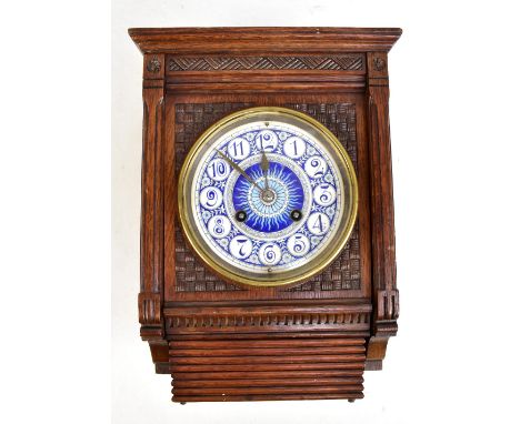 CHARLES FRODSHAM OF PARIS; an Aesthetic Movement wall clock with carved oak case housing a blue and white ceramic dial set wi
