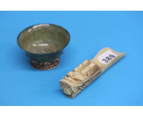 A small Jade coloured decorative bowl with silver coloured mounts and a carved ivory shoe horn (2)