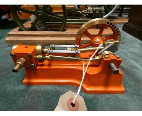 A brass live steam stationary engine and a smaller brass and red engine, the large one approx 11" x 5", 6" tall and the small