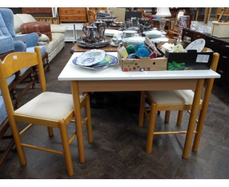 A modern white kitchen table and a pair of light beech dining chairs 