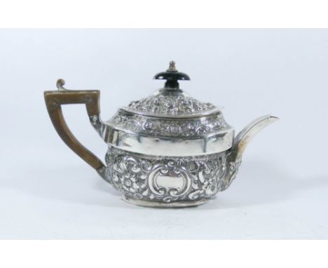 Silver bachelors teapot with embossed decoration, London marks 1896. Weight all in 7 troy ounces. 13 cms tall including woode