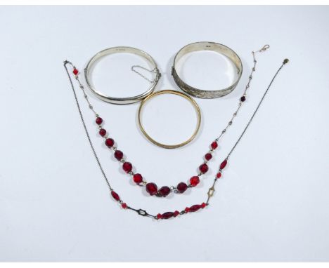 Two silver hinged ladies bangles, a rolled gold childs bangle and a vintage red paste set necklace